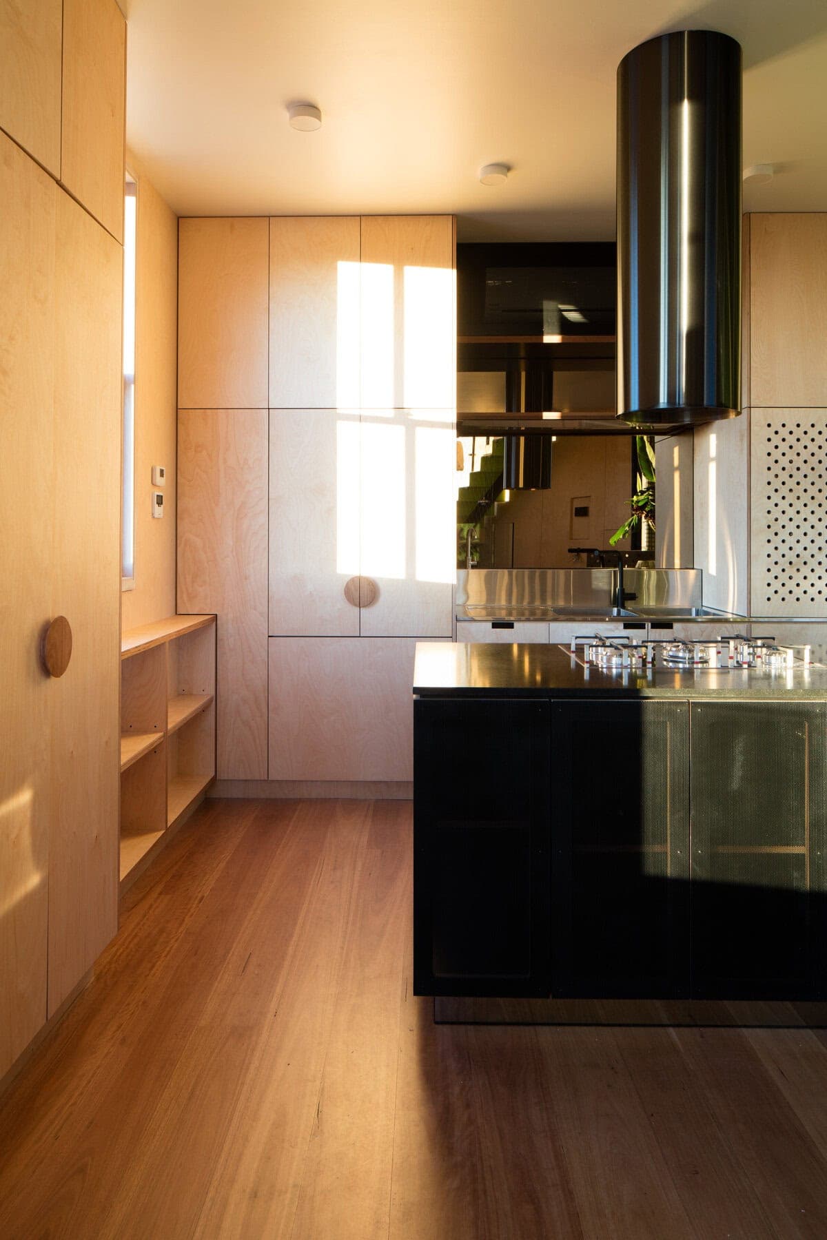 Stylish modern kitchen featuring warm wood tones and a sleek black island design.