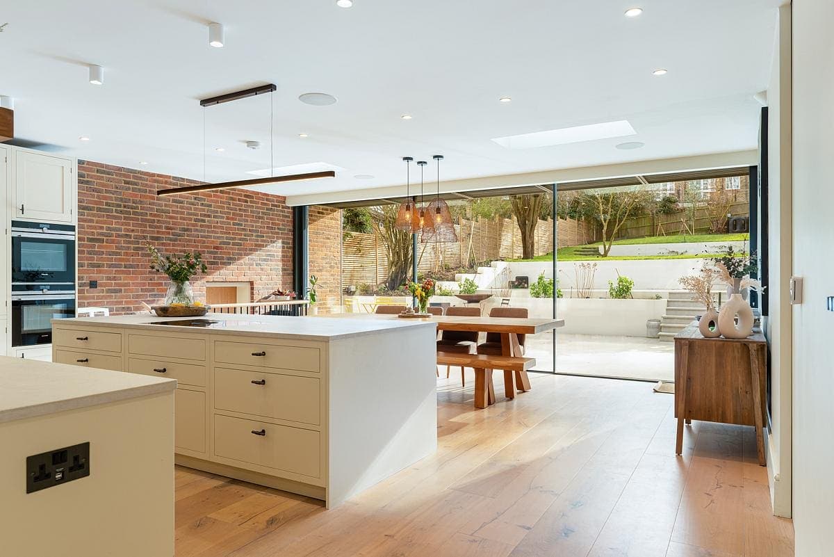 Contemporary kitchen with natural lighting, inviting outdoor views, and modern, warm design elements.