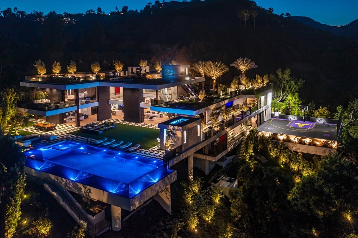 Modern mansion at night with infinity pool and stunning mountain views. Luxurious outdoor living.