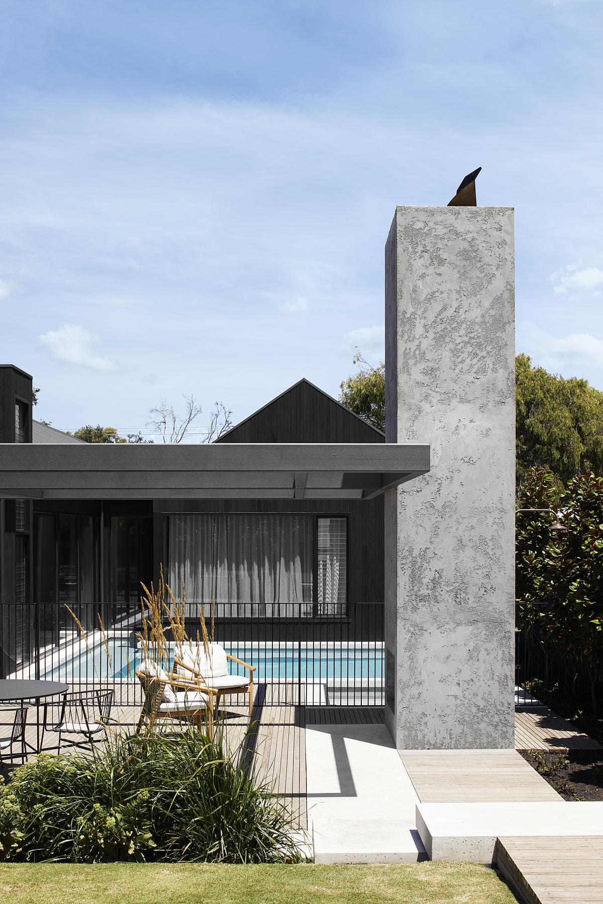 Contemporary minimalist architecture featuring a serene pool and lush landscaping for relaxation.