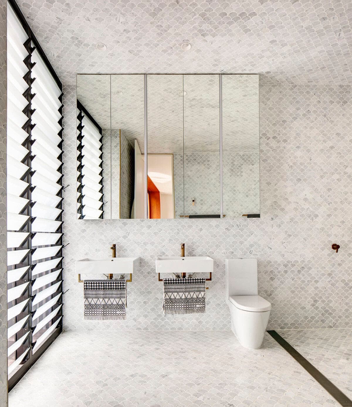 Contemporary minimalist bathroom featuring natural light, sleek design, and elegant marble finishes.