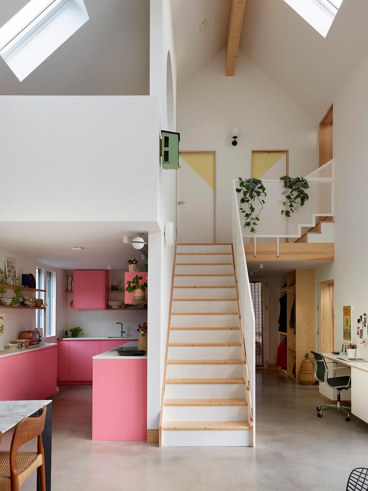 Stylish contemporary home interior featuring open spaces, pink kitchen cabinetry, and natural light.