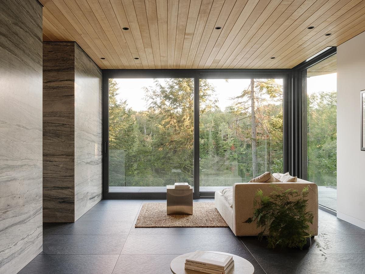 Contemporary minimalist living room with elegant marble wall and abundant natural light.