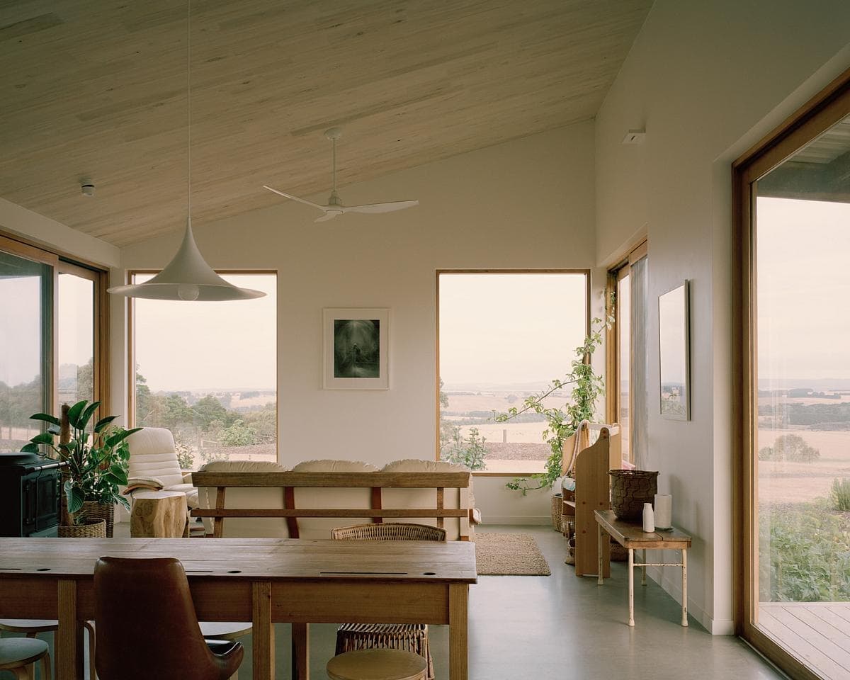 Serene modern living space blending minimalist design and nature through ample natural light.