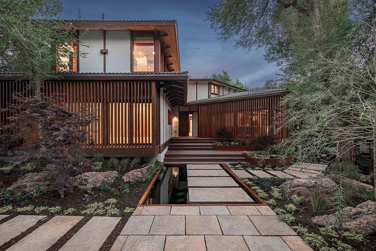 Serene modern home blending with nature, featuring wood, glass, and tranquil landscaping.