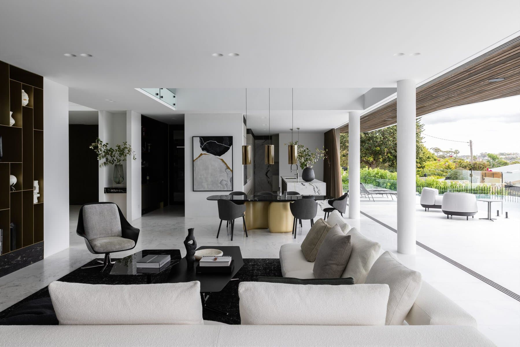Modern open-concept living and dining area with minimalist design, white colour scheme, and outdoor extension.