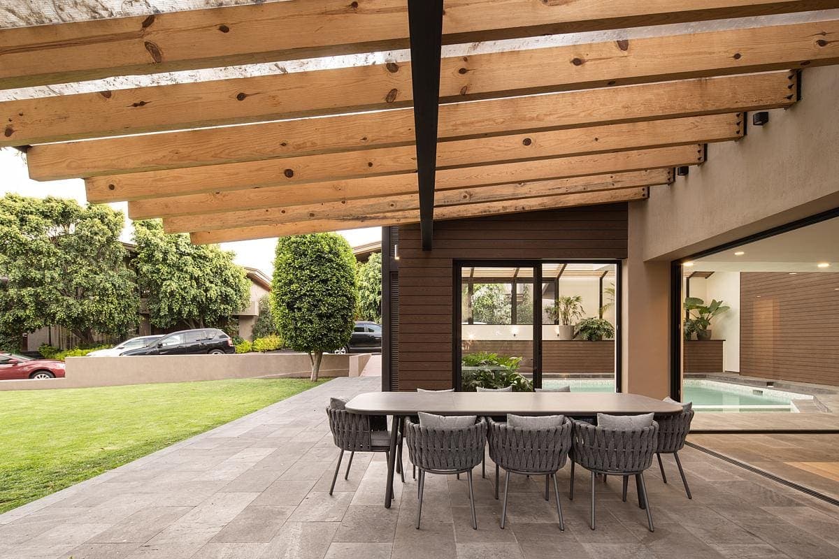 Stylish outdoor porch with dining area, blending modern design and natural surroundings.