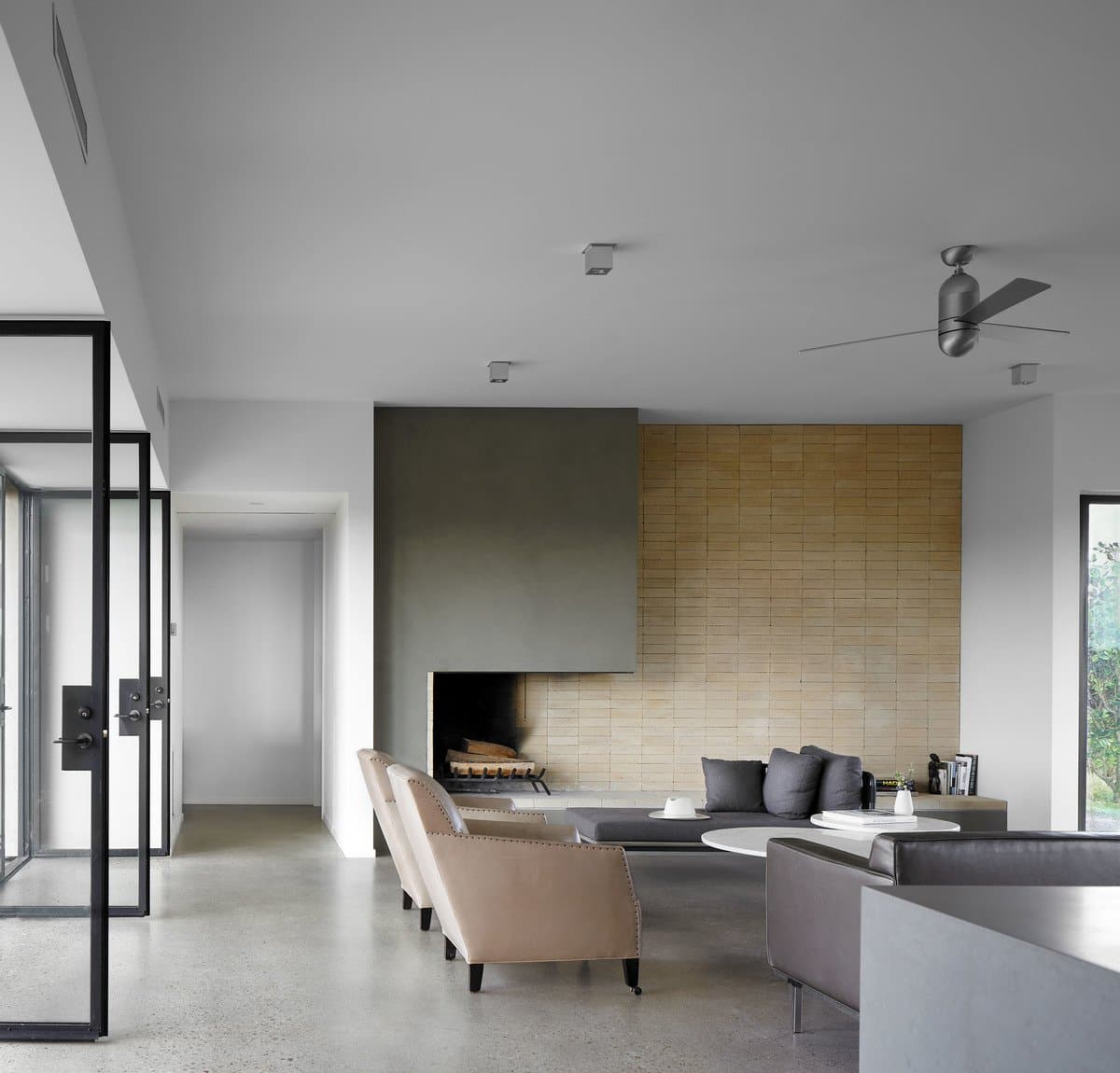 Modern minimalist living room with neutral colours and distinctive fireplace.