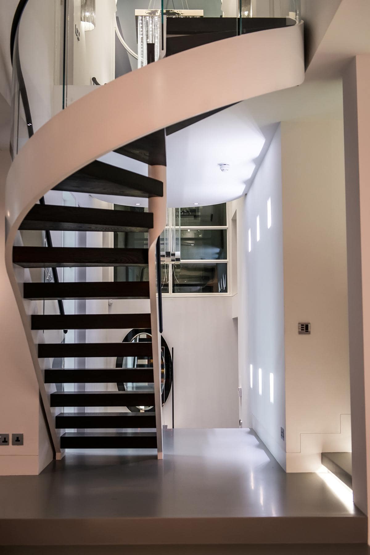 Stylish spiral staircase enhances a bright, modern interior with elegant design and natural light.