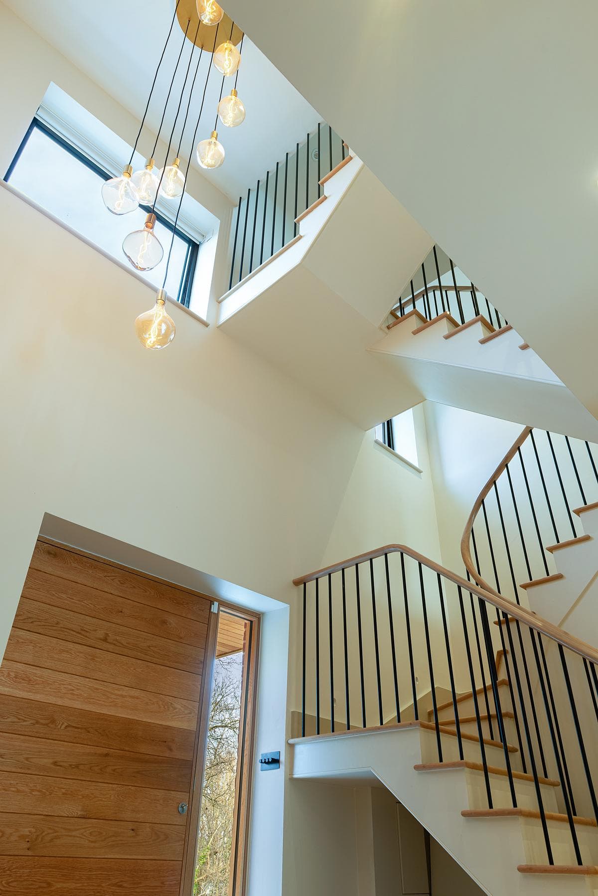 Stairwell with straight flights, dark balustrades and rooflights.