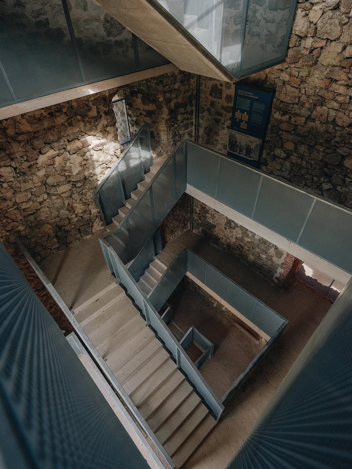 Inserted metal stairs and landings within historic masonry walls.