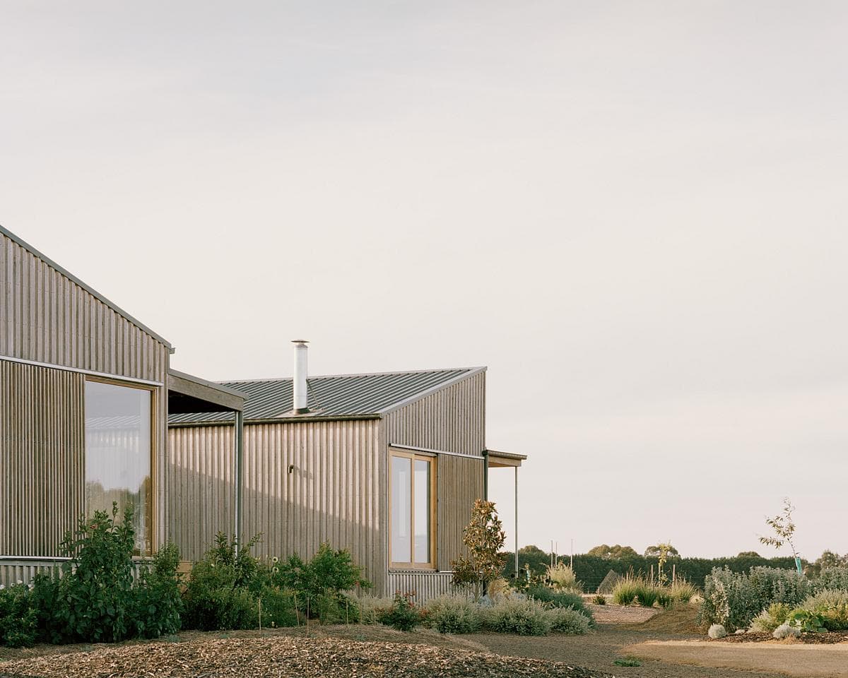 Contemporary timber homes blending into a serene landscape with abundant greenery and natural light.