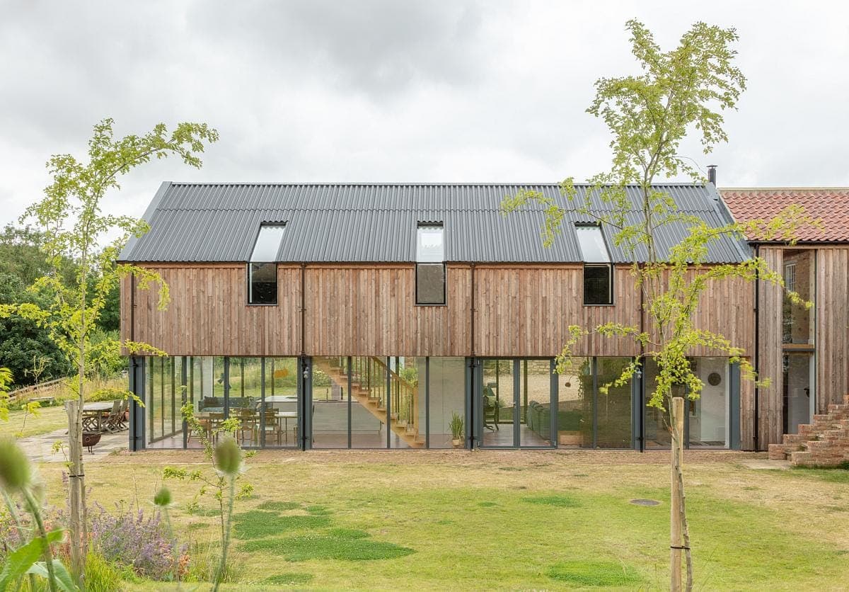 Contemporary wooden house surrounded by lush greenery, blending modern design with natural beauty.