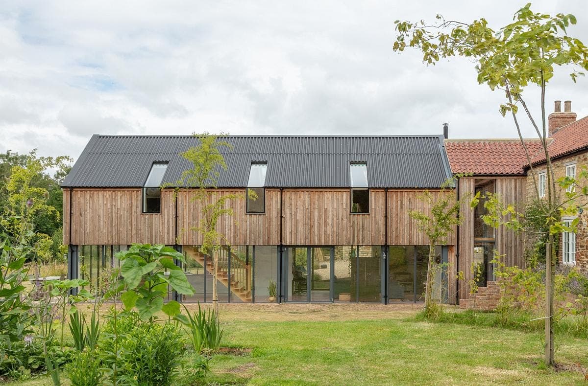 Contemporary wooden house nestled in vibrant greenery, blending modern design with nature.