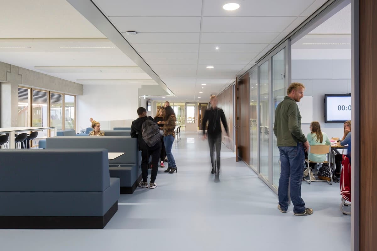 Modern educational building with booths, natural light, casual attire, and collaborative spaces.