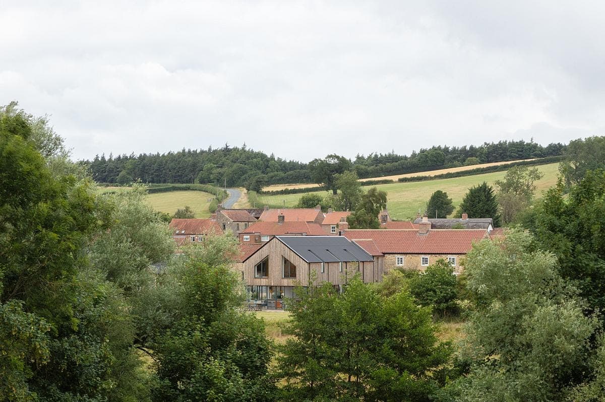 Picturesque rural village with charming homes surrounded by verdant hills and fields.