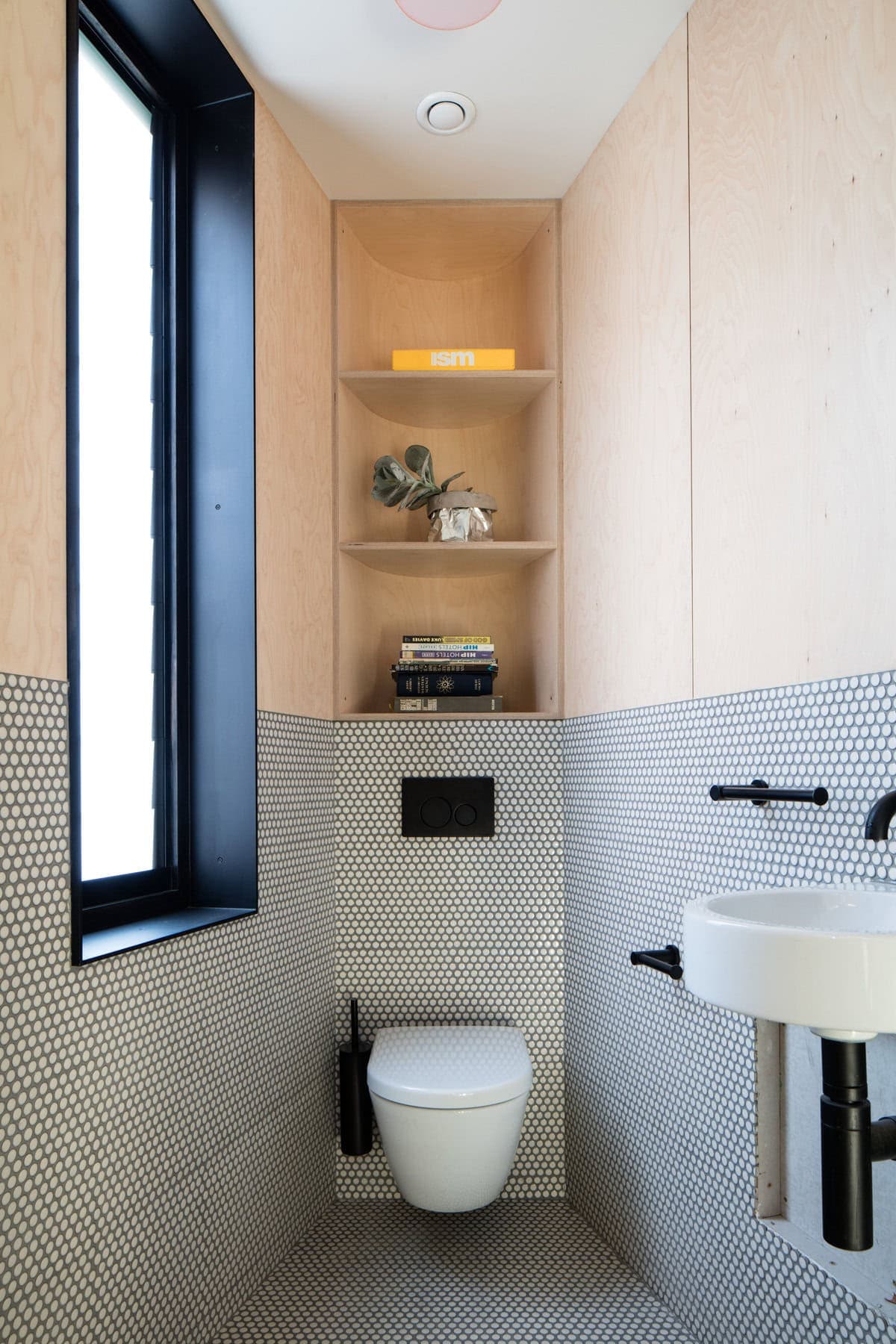 Contemporary minimalist bathroom with wood paneling and stylish black-and-white tile accents.