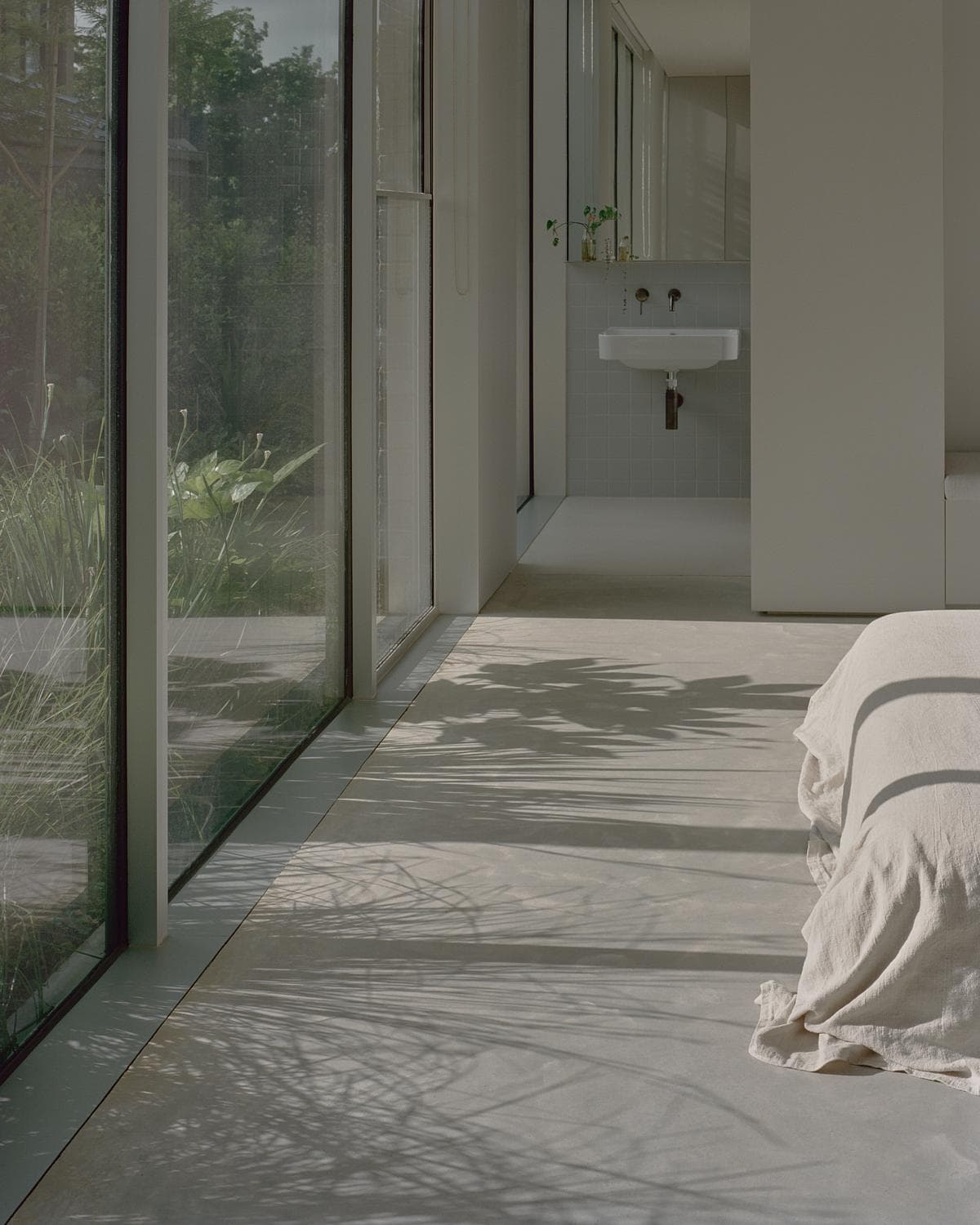 Serene modern interior with natural light, minimalist design and lush greenery harmonising indoors and outdoors.