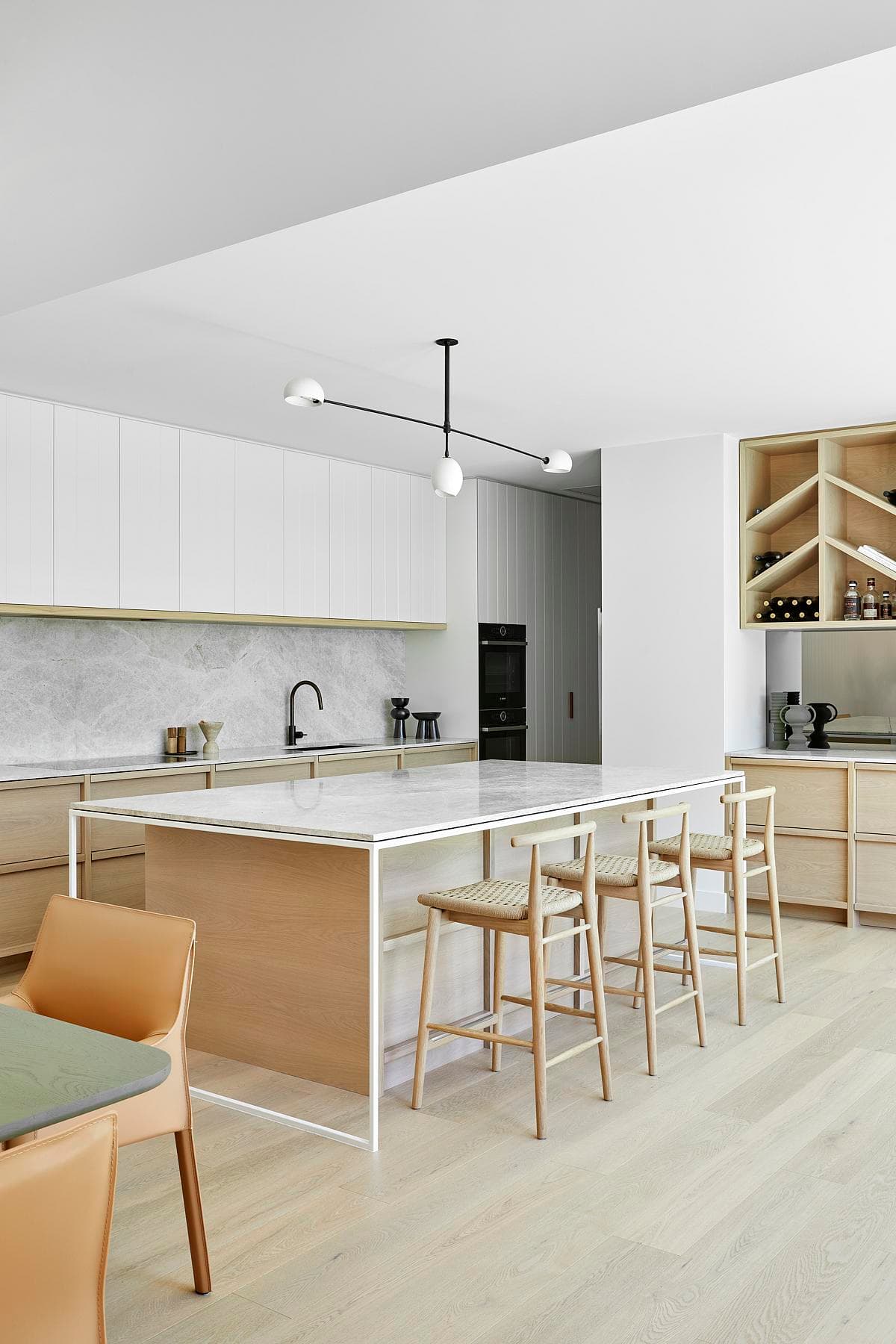 Contemporary kitchen with stylish island, wooden cabinetry, and elegant marble backsplash for modern living.