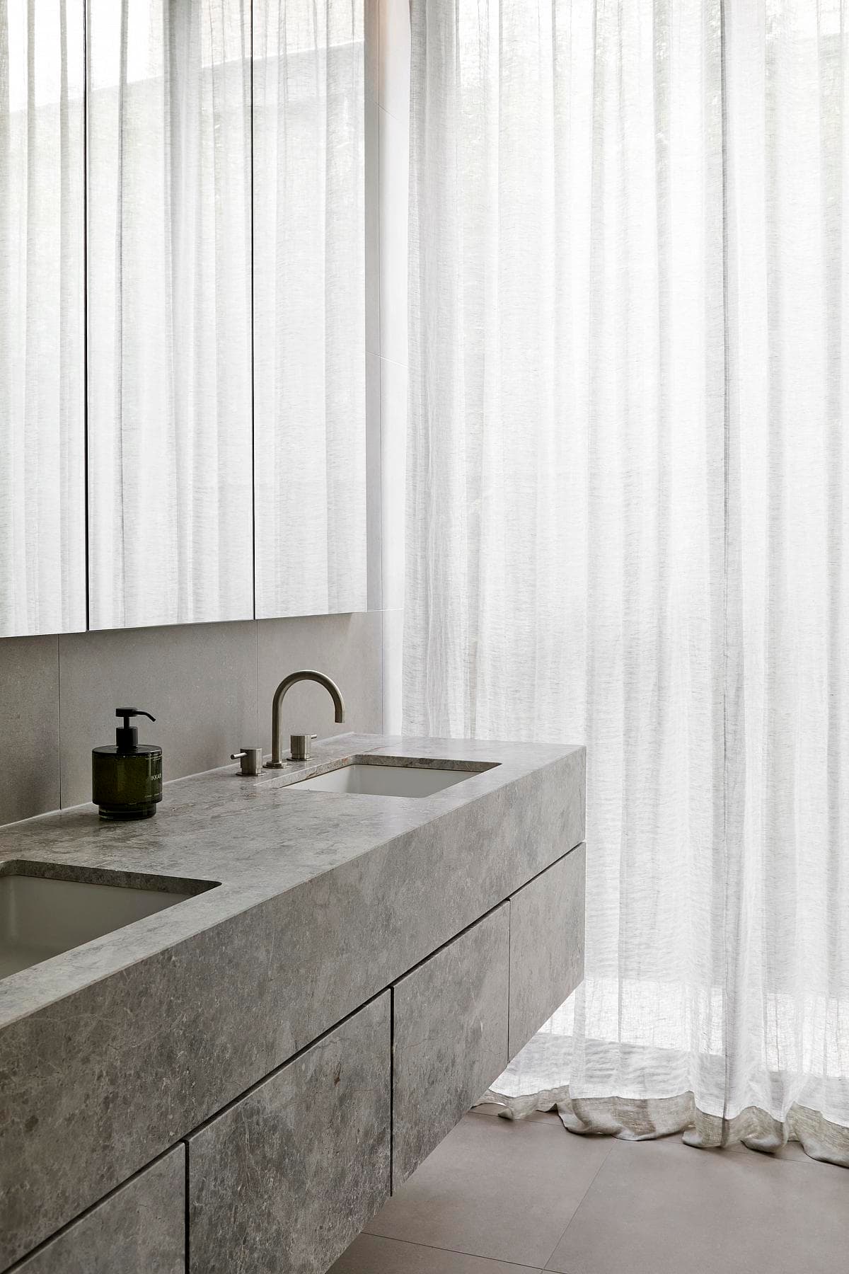 Modern minimalist bathroom with natural light and elegant design for a relaxing atmosphere.