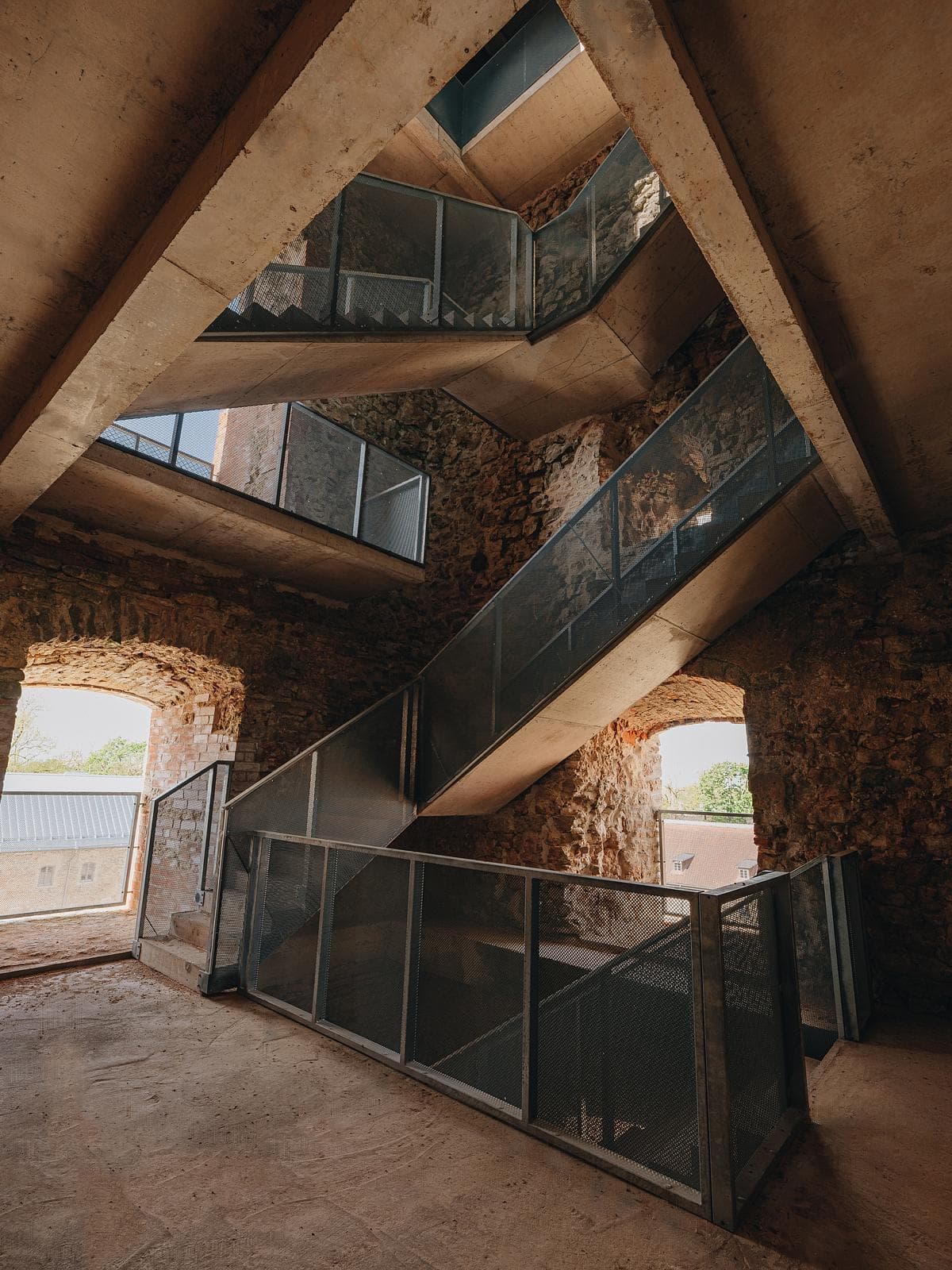Contemporary staircase seamlessly integrates with historical stone walls, showcasing architectural harmony.