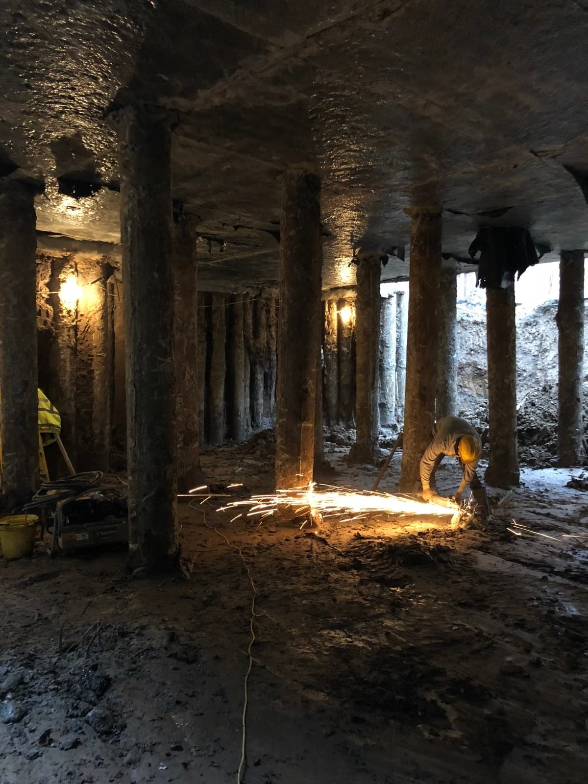 Basement excavation beneath the building, with temporary supports and construction equipment.