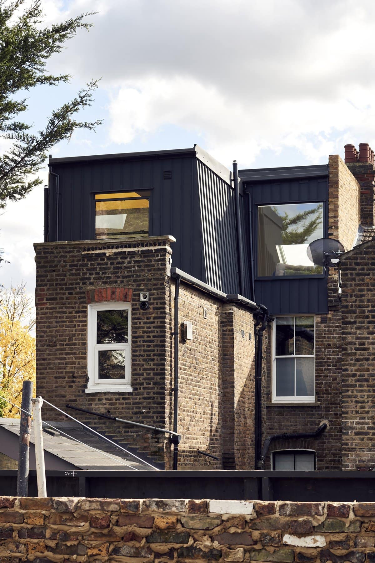 Rear view of urban residential building with modern loft conversions and vintage brickwork.