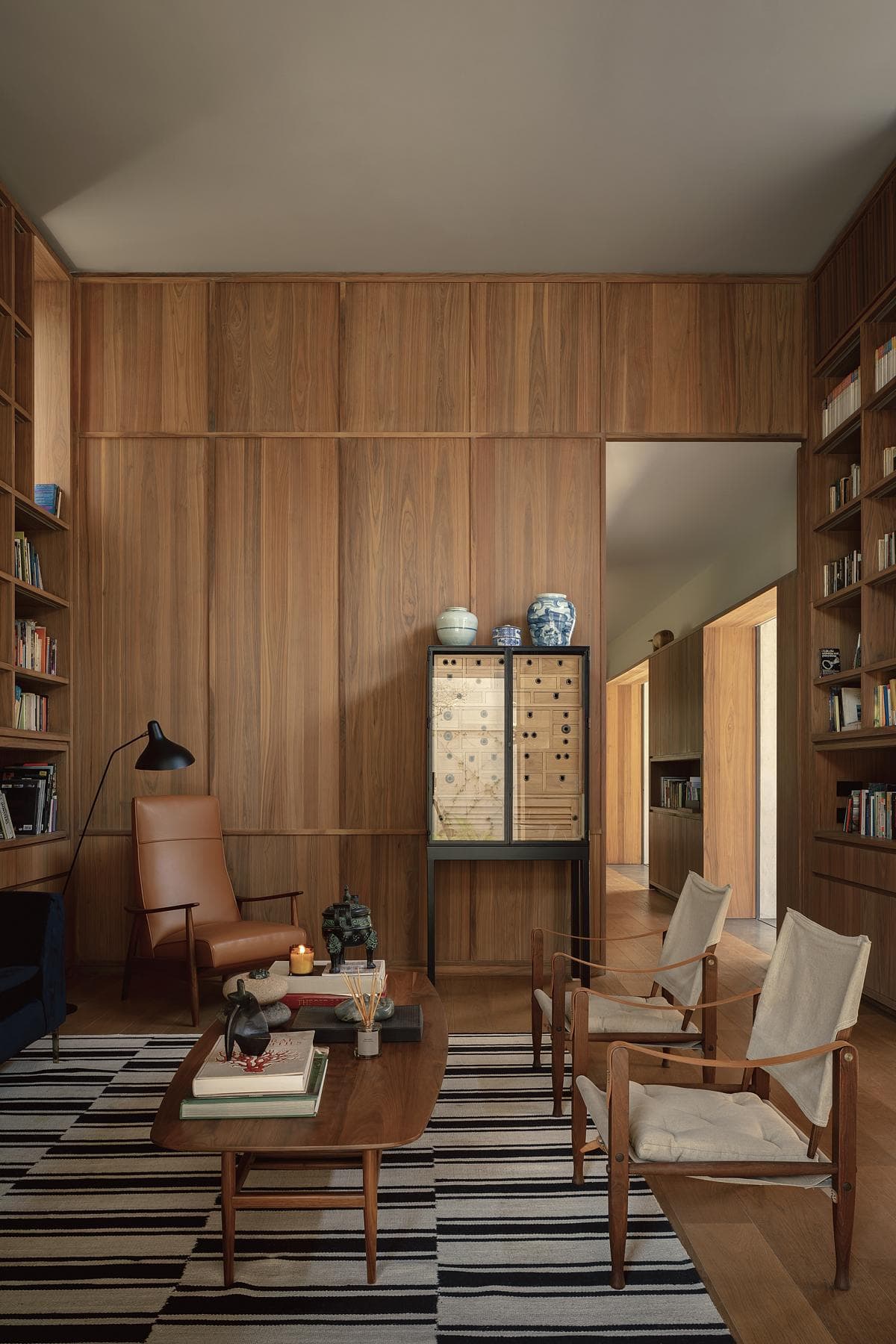 Elegant wood-panelled living space with inviting decor, stylish furniture, and warm lighting.