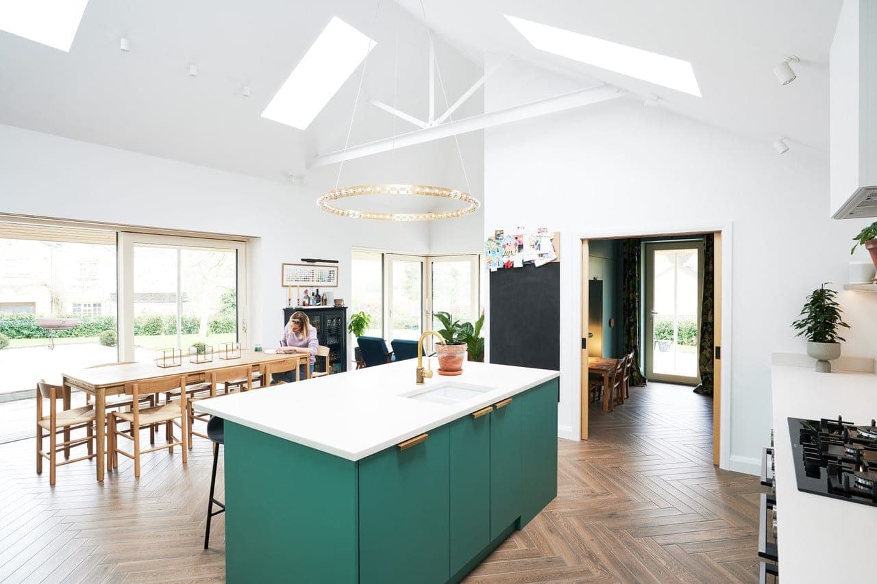 Kitchen island and dining table in an open-plan room with sliding doors to the garden