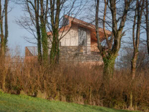 Cairn House by 2020 Architects, exterior view of stone wall feature