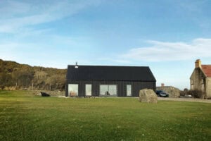 The Black Cottage by 2020 Architects, fibre cement clad cottage overlooking Ardglass marina