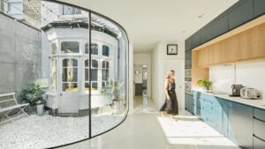 Curved glass courtyard wrapping the existing Victorian bay window at Lansdowne Road by Mulroy Architects