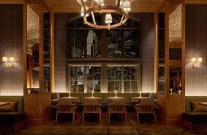 Elegant dining area with arched window, plush seating, and warm lighting. Ideal for social gatherings.