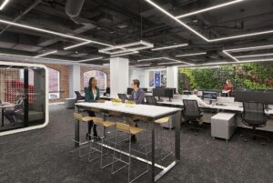 Modern open-plan office with industrial design, biophilic elements, and collaborative spaces.