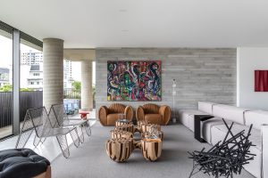 Modern living room with natural light, abstract art, and stylish furniture arrangement.