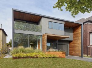 Contemporary two-story house with minimalist design, large windows, and mixed materials in a suburban setting.