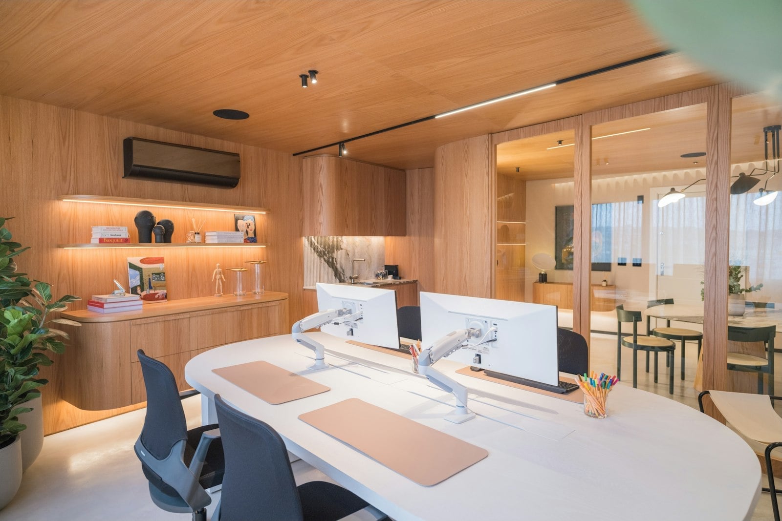 Modern architect workspace with dual computer monitors, wooden accents and natural light
