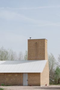 Contemporary brick building with a charming chimney, nestled in a tranquil natural setting.
