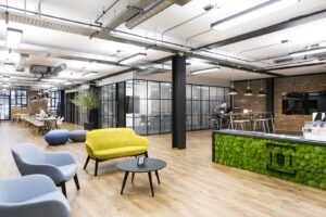 Modern open-concept office with industrial and contemporary design, featuring vibrant seating and collaborative spaces.