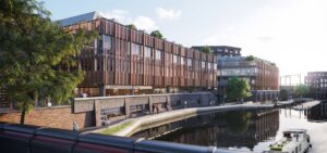 Modern waterfront building complex with a canal, pathways, greenery, and communal seating areas.