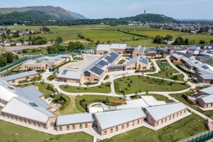 Aerial view of modern sustainable rural campus with solar roofs and landscaped paths.