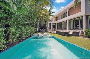 Luxurious modern home with pool and lush greenery at 301 West Palmwood Dr, Key Biscayne, FL.