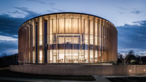 Modern circular building with glass facade and wooden slats by Richärd Kennedy Architects.
