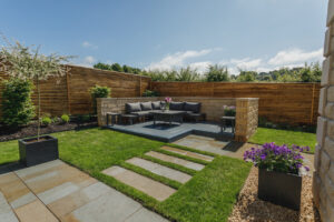 Modern backyard with contemporary seating area on raised wooden platform.