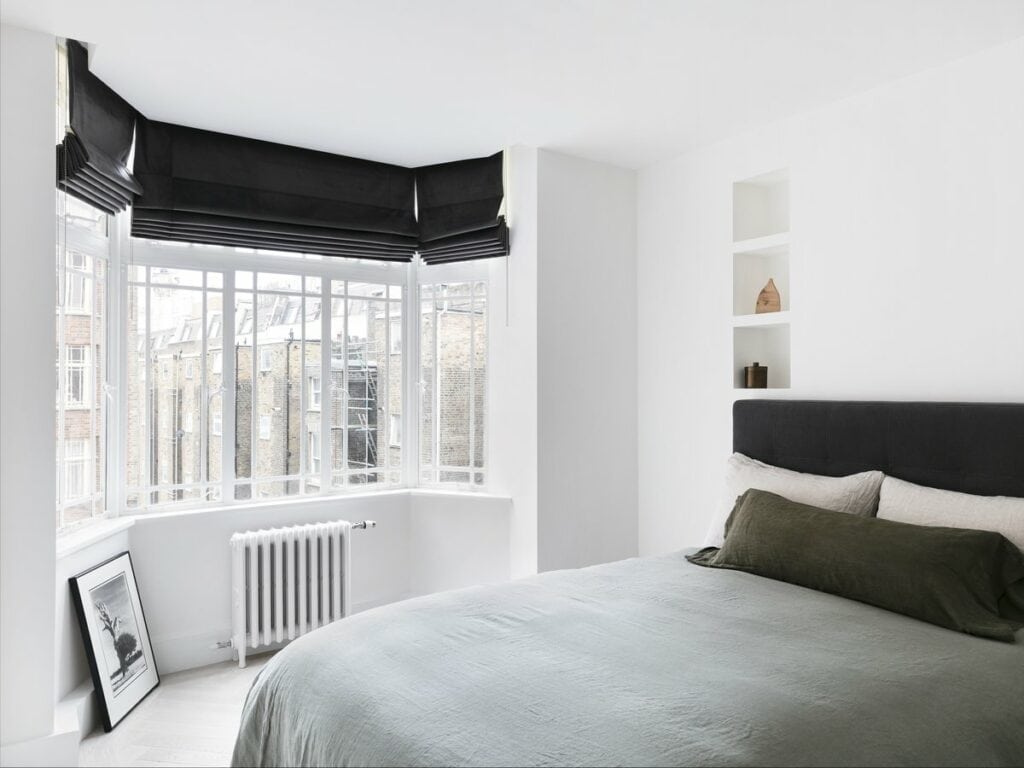 Modern minimalist bedroom with neutral tones, natural light, and sleek design elements.