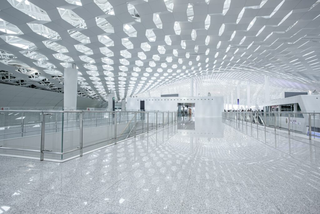 Modern architectural space with perforated ceiling and polished reflective floor.