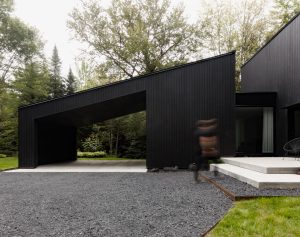 Contemporary black architecture harmonising with lush nature, inviting connection and livability.