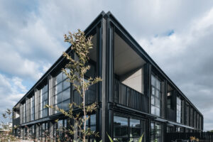 Modern two-story building with sleek design by CHT Architects, featuring large glass windows.