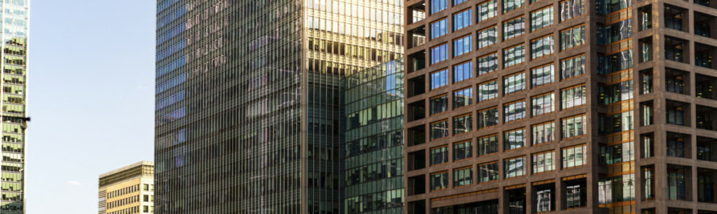 Modern high-rise buildings with glass and brick facades at sunset in London.