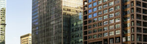 Modern high-rise buildings with glass and brick facades at sunset in London.